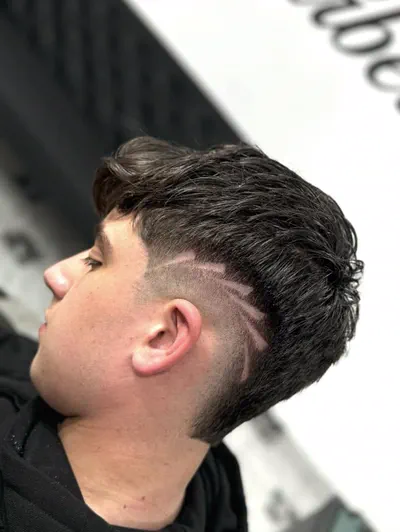 Tunsoare fade cu model din linii pe lateral, la păr închis la culoare